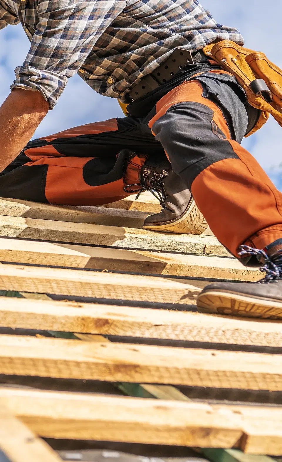 Tradesperson working on a timber roof. Illustrative photograph, not a completed Ecobuild job.